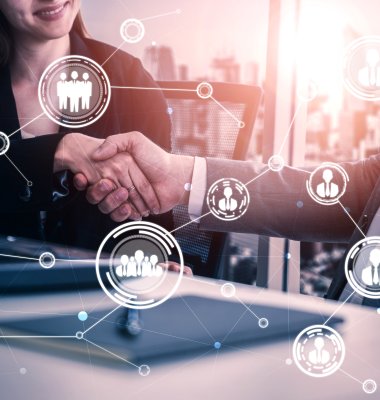 Graphic people and team icons against a photo background of 2 people shaking hands