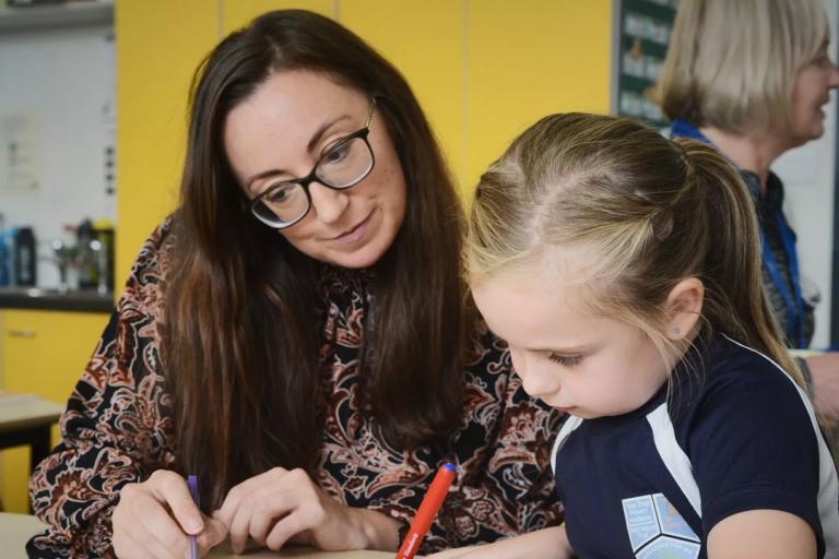 A photograph of a teacher and a student at Yew Tree Primary.