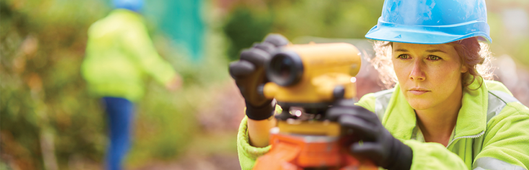 A photograph of a female site surveyor using equipment