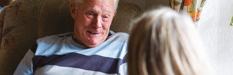 Photograph showing an elderly man talking to somebody